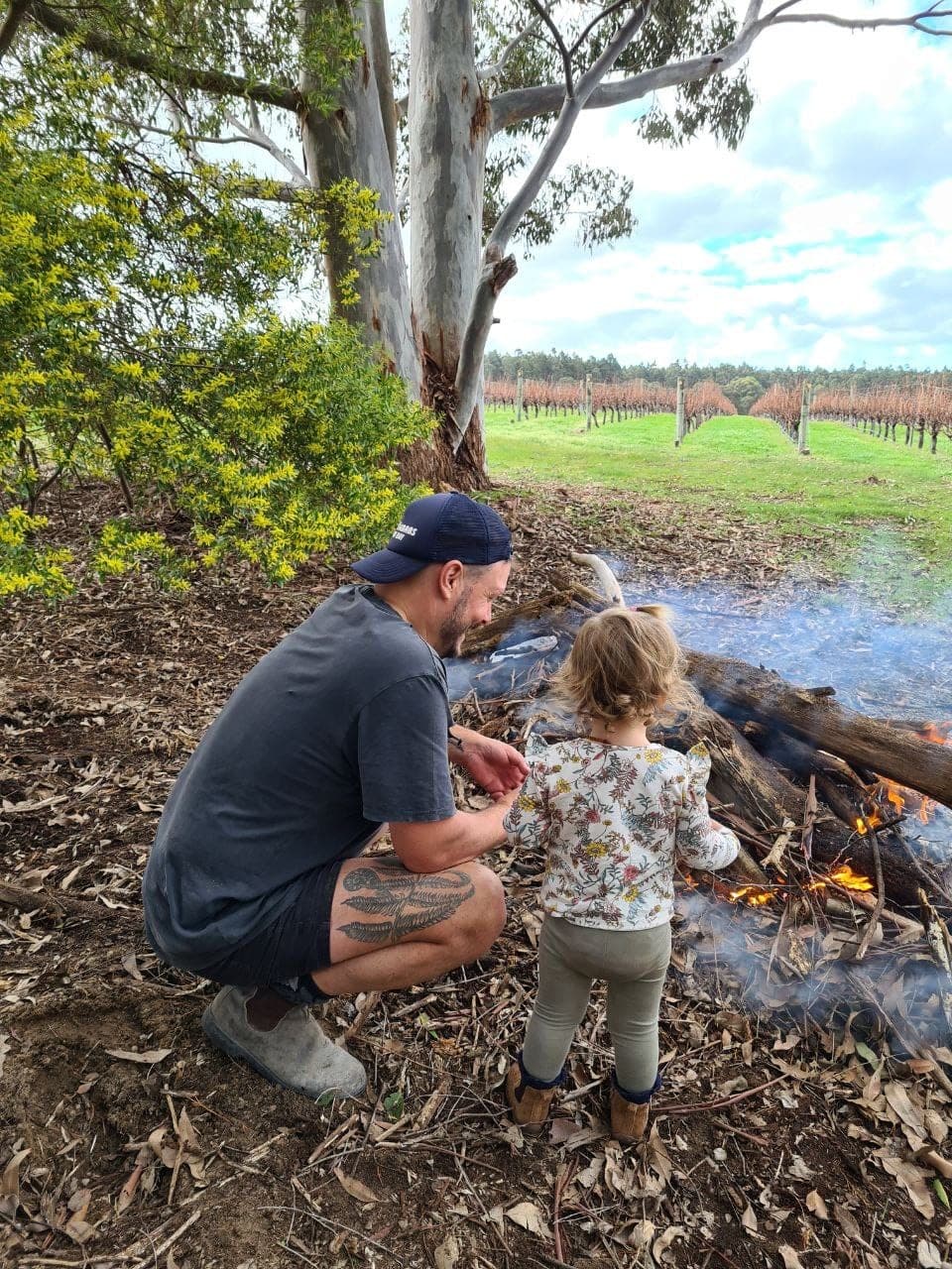 Father and daughter tending a fire beside the vines at The Green Park